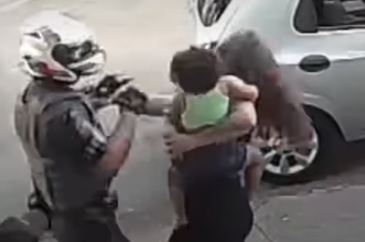 Mulher com bebê no colo dá tapa em PM e é derrubada com soco