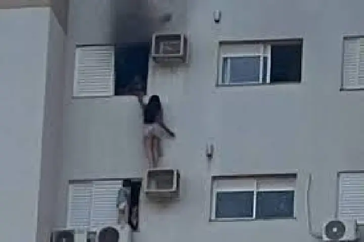 Mulher se pendura em ar-condicionado para escapar de incêndio