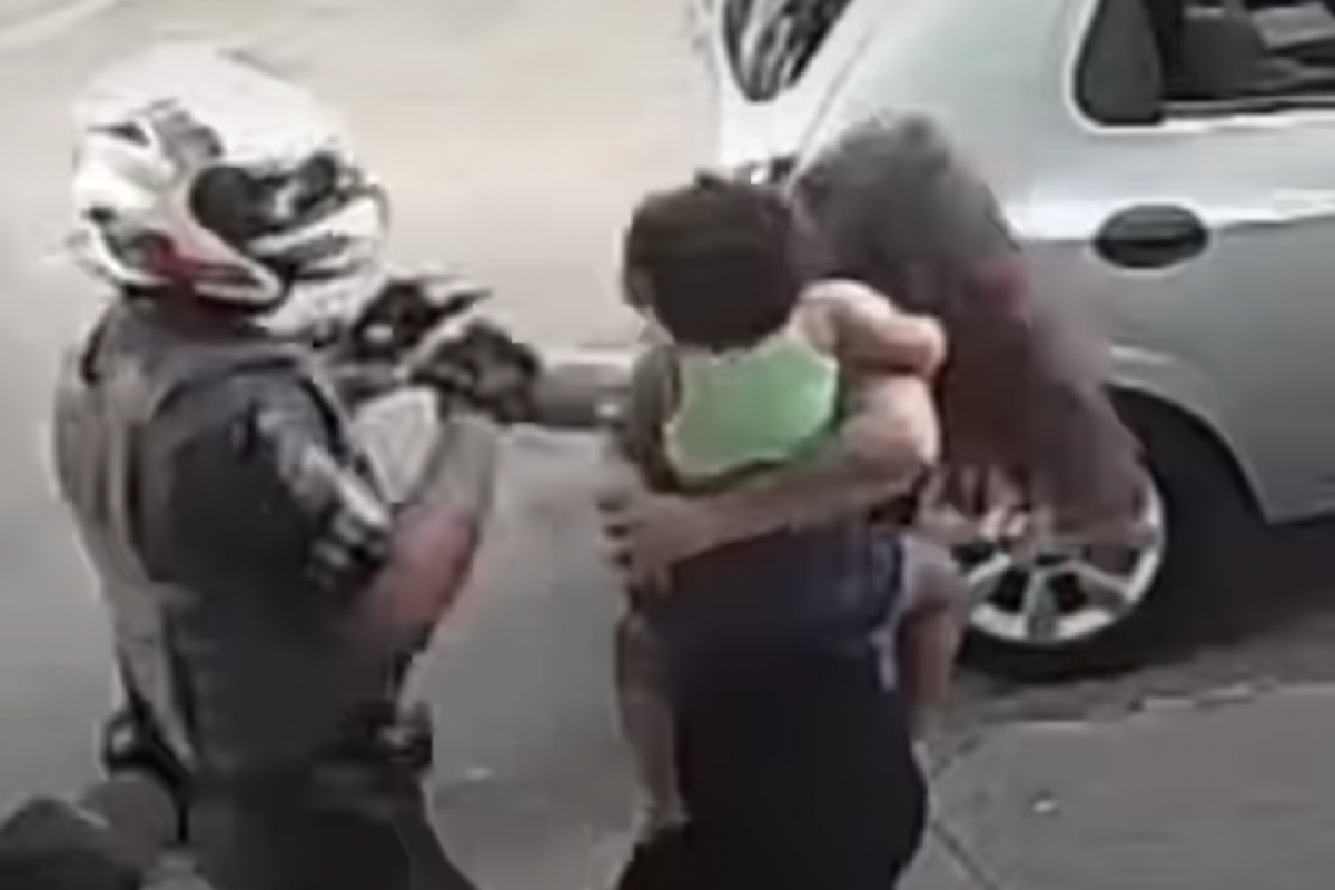 Mulher com bebê no colo dá tapa em PM e é derrubada com soco